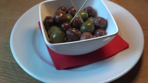 Extreme close-up moving shot (left to right) at 30fps of a bowl with olives Stock Footage 303772548