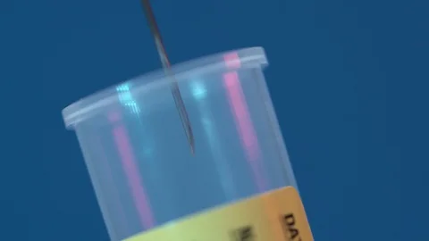Extreme close up of the needle that enters into the test tube blue background Video stock 128343362