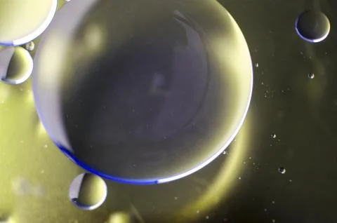 Extreme close up of oil bubbles with gradient light yellow background Stock Photos