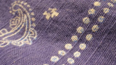 Extreme close-up over blue and white paisley patterned fabric. Stock Footage 151978542