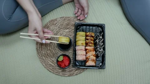 Extreme close-up overhead view of hands holding a sushi roll with chopsticks Stock-Footage 347009348