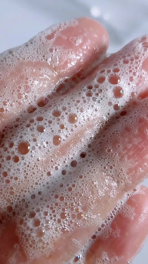 Extreme close up of palm covered in soap bubble foam. Hand hygiene, white c.. Vídeo Stock 335022684