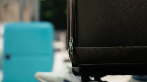 Extreme close up of passenger pulling trolley across bus station Stock Footage 340201851