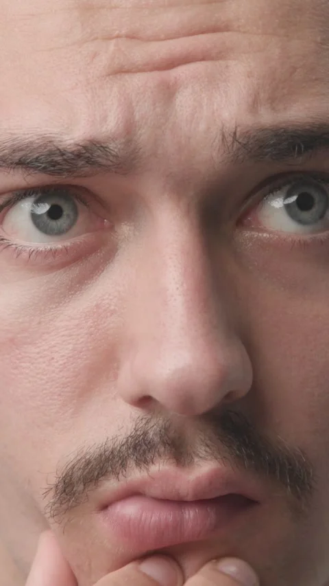 Extreme Close-up of Pensive Young Man Touching Chin and Thinking Stock Footage 341659484