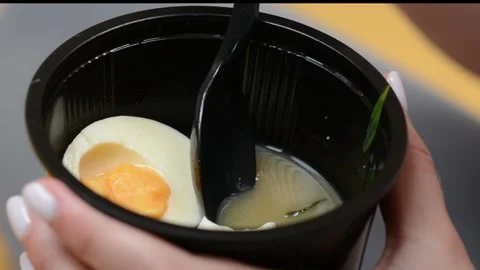 Extreme close-up of a plastic takeaway container filled with soup Video stock 346638182
