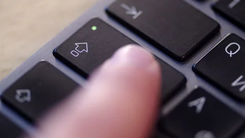 Extreme close up, pressing the Caps Lock key on a black keyboard. Video stock 340959085