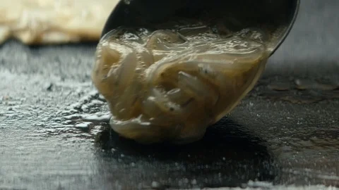 Extreme close up raw whitebait placed onto hot stove Stock Footage 89994532
