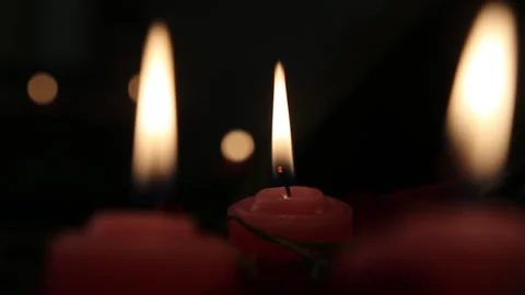 Extreme Close-up of Red Candles Flickering in Darkness Stock Footage 328042819