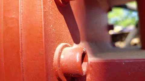 Extreme close up of red painted allen socket head cap screws on industrial equip Stock Footage 336008108