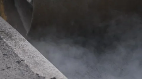 Extreme close up of road roller metal drum compacting fresh asphalt near curb Stock Footage 339802461
