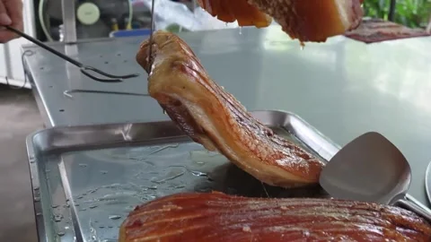 Extreme Close-up of Roasted Pork Belly with Golden Crispy Skin on Metal Tray Stock Footage 338211169