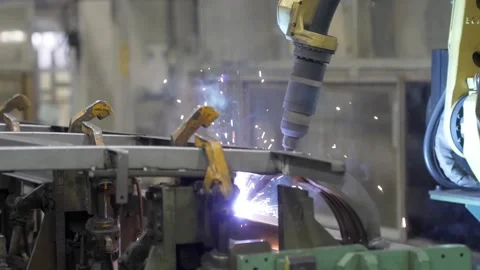 Extreme close-up of a robotic welding torch creating sparks while joining metal Stock Footage 332141891
