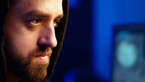 Extreme close up of rogue programmer running code in graffiti painted basement Stock Photos