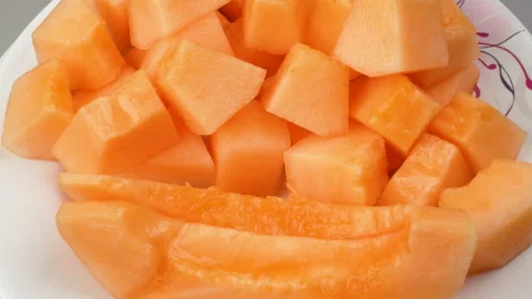 Extreme Close Up Rotating Fresh Orange Melon Cubes On Plate 4K Stock Footage 323079714