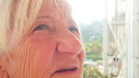 Extreme close-up of a senior woman's face in bright sunlight. Detailed view of Stock Footage 334576094