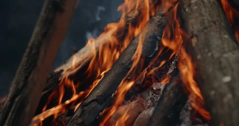 Extreme close-up of shamanic fire with stacked logs and vivid orange flames Vidéo 325335876