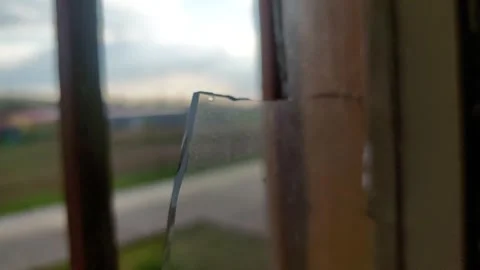 Extreme Close-up of Sharp Shards of Broken Glass in a Window Frame 库存影片 334177565