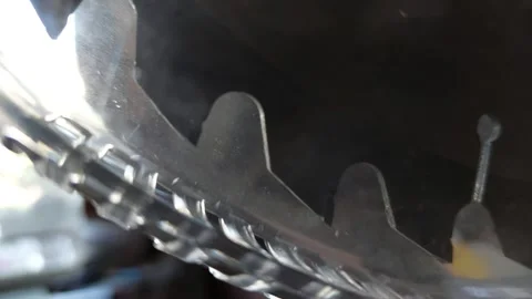 Extreme close-up of sharp teeth of a circular saw blade behind a plastic guard Stock Footage 335644447