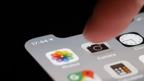 Extreme close up shot of the camera icon on the iPhone, finger launching Stock Footage 123551426