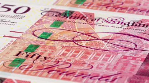 An extreme close-up shot panning over multiple 50 pound sterling banknotes. Stock Footage 137809832