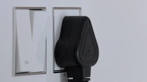 Extreme close shot of a switch board, black male hand plugs the laptop charger Stock Footage 147240726