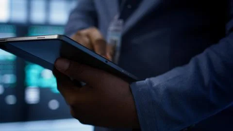 Extreme close up shot of worker in server hub using tablet Stock Photos