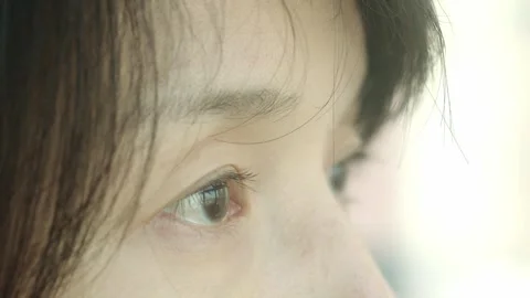 Extreme Close-up Side Profile of Woman's Eye with Dark Hair Strands Vídeos de archivo 334639198