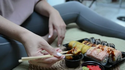 Extreme close-up side view of hands holding sushi with chopsticks Vídeo Stock 347009353