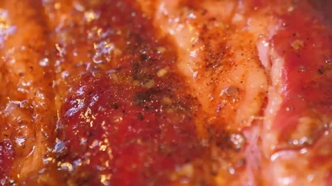 Extreme Close-Up of Sizzling Grilled BBQ Pork Steak with Savory Glaze Stock Footage 338212510