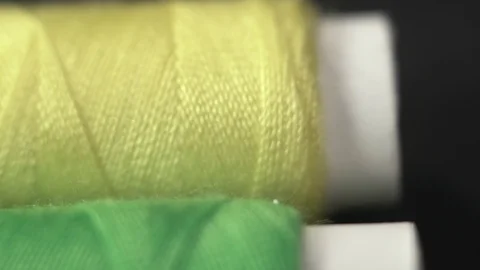 Extreme close up of skeins of thread lie on black table. The camera slowly dolly Stock Footage 128993795
