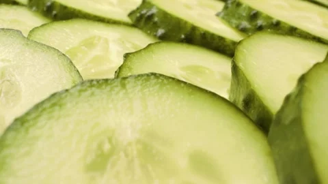 Extreme close-up of sliced cucumbers captured with a sliding motion. Stock Footage 313833032