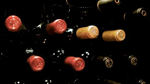 Extreme close-up sliding shot of wine bottles stacked on a shelf Stock Footage