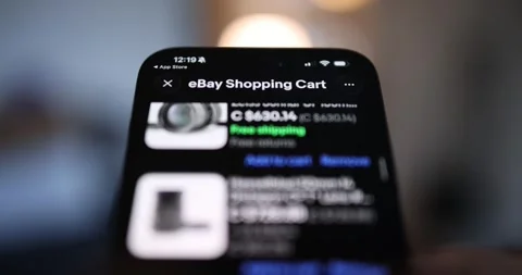 Extreme close-up of a smartphone screen showing the eBay Shopping Cart app Stock Footage 333705713