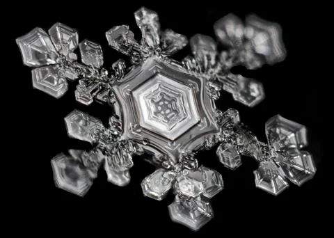 Extreme close up of snowflake on black background, structure and natural Stock Photos