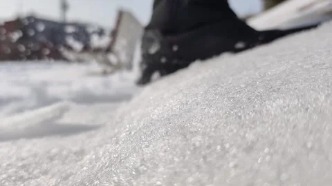 Extreme close-up of sparkling snow texture with hiking boots walking past. L Stock-Footage 328402811