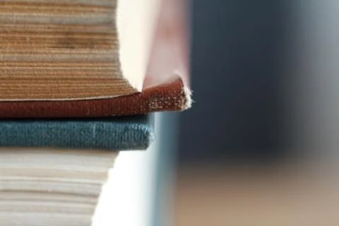 Extreme close-up of a stack of old books, yellowed pages, a broken back of a  Stock Photos