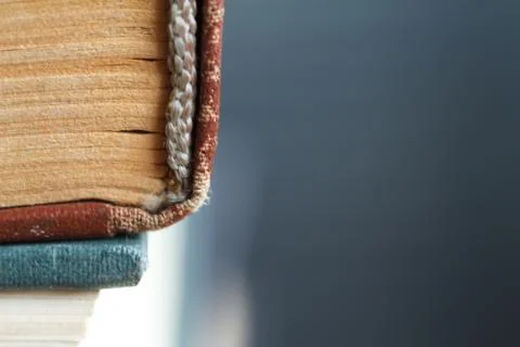 Extreme close-up of a stack of old books, yellowed pages, a broken back of a  Stock Photos