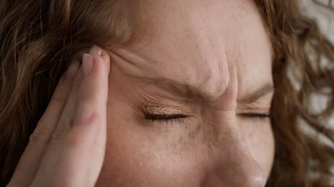 Extreme close up studio shot of young caucasian woman having migraine Stock Footage 164454267