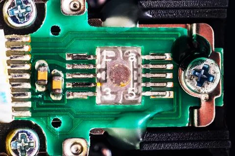 Extreme close-up of a surface-mount component on a green circuit board with.. Stock Photos