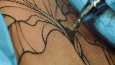 Extreme close-up of tattoo machine needles at work and hands of a tattoo artist Vidéo 317333486