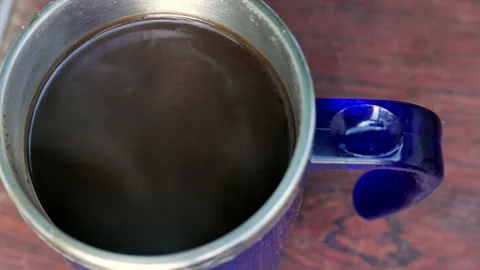 Extreme close-up (top view): a thermal coffee cup on a table. Dense steam rising Stock Footage 346351534