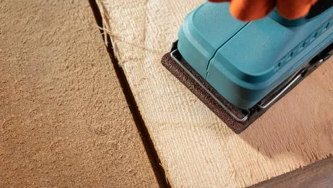 Extreme close up of a vibration sander base smoothing a wooden surface. Macro Stock Photos