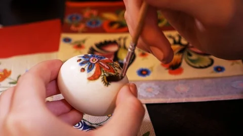 Extreme close up view of artist�s hand coloring the egg, decorated egg with a Stock-Footage 99361176