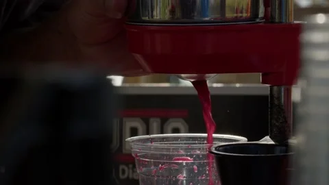 Extreme close up view of flowing red juice in plastic glass on street Stock-Footage 227247167