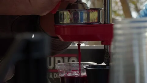 Extreme close up view of flowing red juice in plastic glass on street Stock Footage 227613247