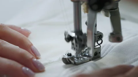 Extreme close-up view of hands sewing some clothes with white fabric. sewing Stock Footage 228918348