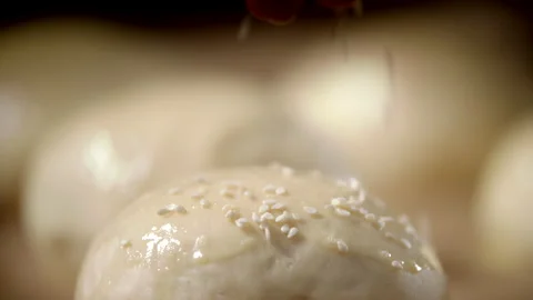 Extreme Close Up View Of Hands Sprinkle Sesame Seeds On Dough For Buns Stock Footage 170241386