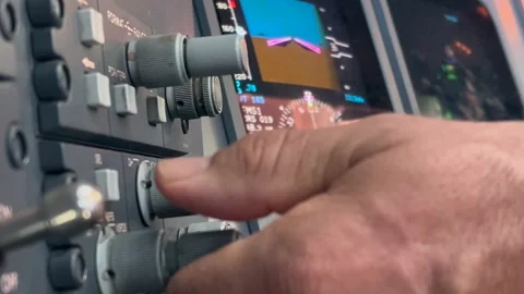 Extreme close-up view of the left hand of a white pilot operating knobs to Video stock 285620299