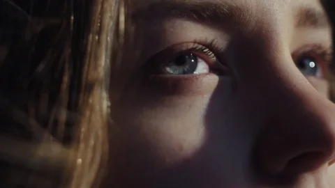 Extreme close up view of young blue-eyed woman looking into the distance, wind Stock-Footage 84643844