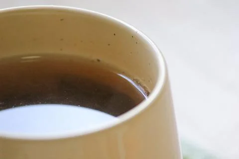 Extreme close up of a warm ceramic mug filled with freshly brewed herbal te.. Foto stock